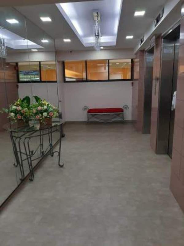 Stylish elevator lobby with mirrored wall, glass table, floral décor at PH Marble Tower Panama City