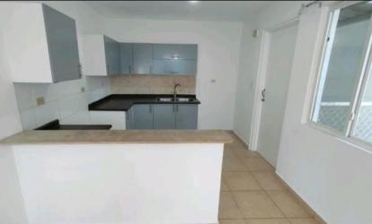 L-shaped modern kitchen with gray cabinets, black countertop, breakfast bar at La Arboledas Costa Verde Panama