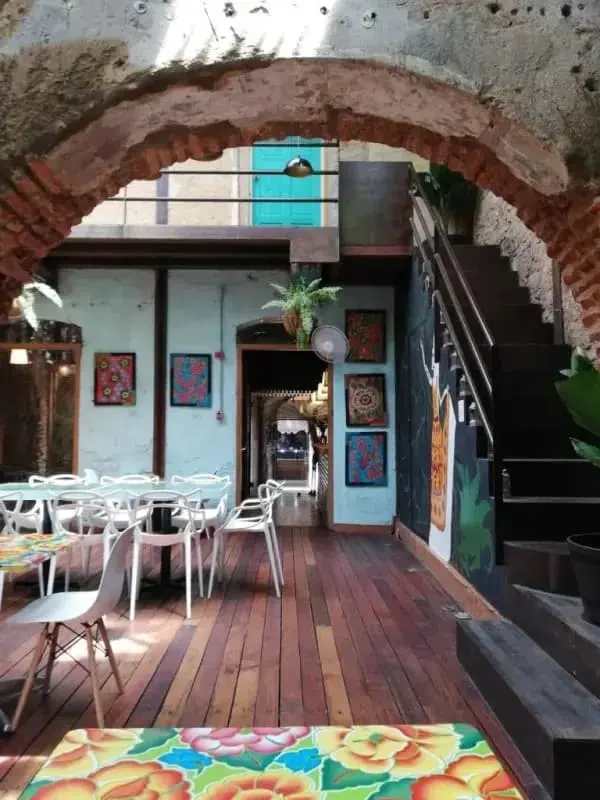 Colorful eclectic lounge and dining with brick arch and blue door in Casco Viejo Panama