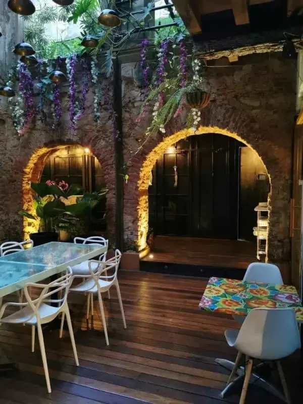 Rustic courtyard dining area with plants and stone arch Casco Viejo Panama