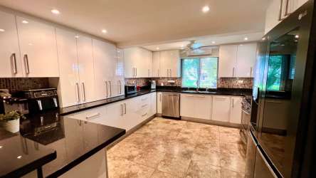 Living room with turquoise accents, modern furniture, ceiling fan at Decameron townhouse Panama beach resort