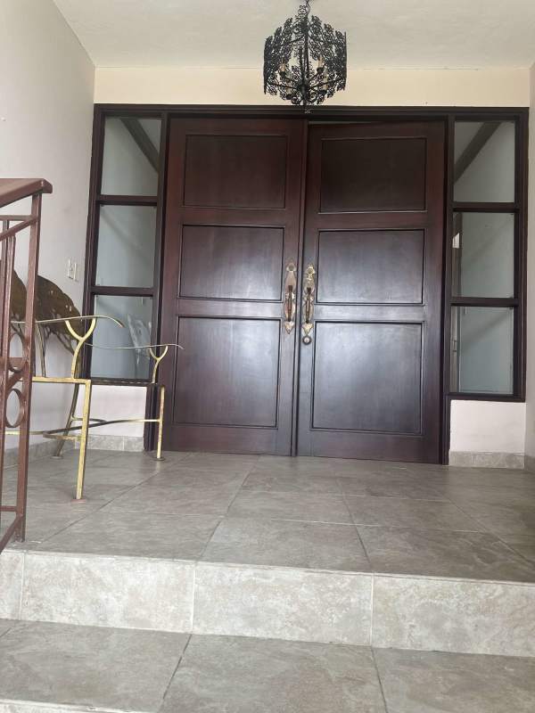 Large covered terrace with outdoor seating and garden in fenced two-story residence Altos de Golf Panama