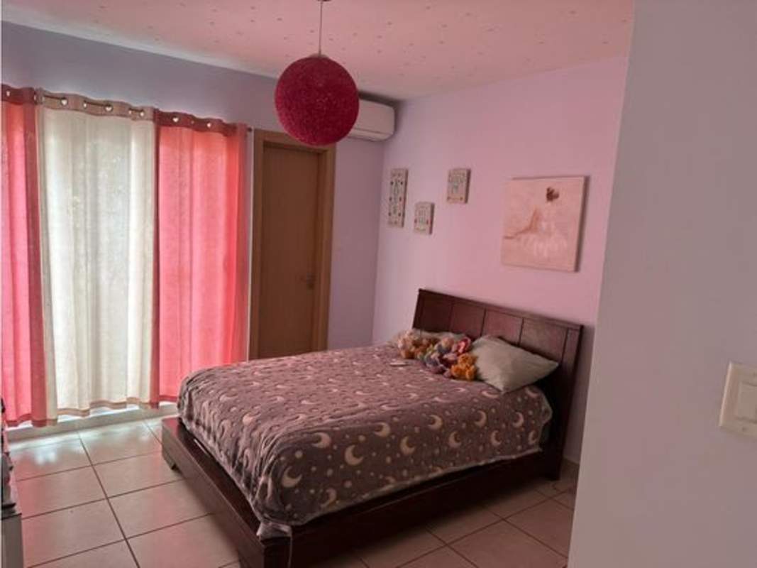 Bedroom with large window, curtains, AC, and wood furnishings at PH Victoria Panama