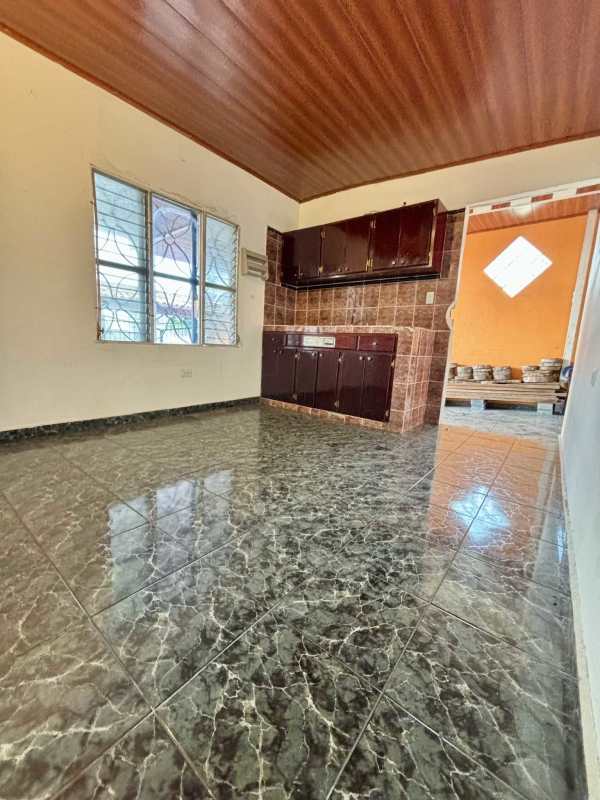 Closed kitchen with tile backsplash, wood cabinets in house for sale Panama