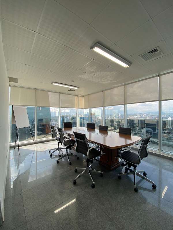Open-plan corporate workspace with glass dividers, polished tile floors, modern lighting inside F&F Tower