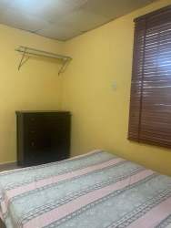 Studio bedroom with natural light, simple furnishings, blinds and tiled floors, Santiago Panama