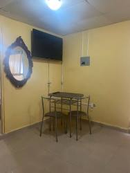 Dining space with table, wall-mounted TV and mirror in furnished studio Santiago Panama