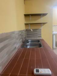Basic kitchenette with sink, shelf, and tiled wall for Santiago rental studio