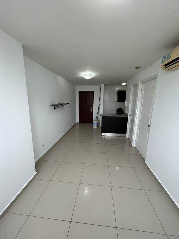 Compact kitchen with granite countertop and white tiled walls in central Panama apartment
