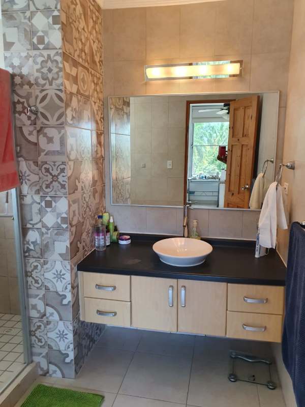 Modern bathroom with vessel sink, patterned tile wall, walk-in shower Ciudad del Saber Panama