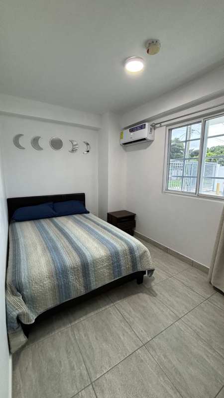 Simple bedroom with teal bedding, large window, ceramic flooring in PH Villa Lua Tocumen Panama