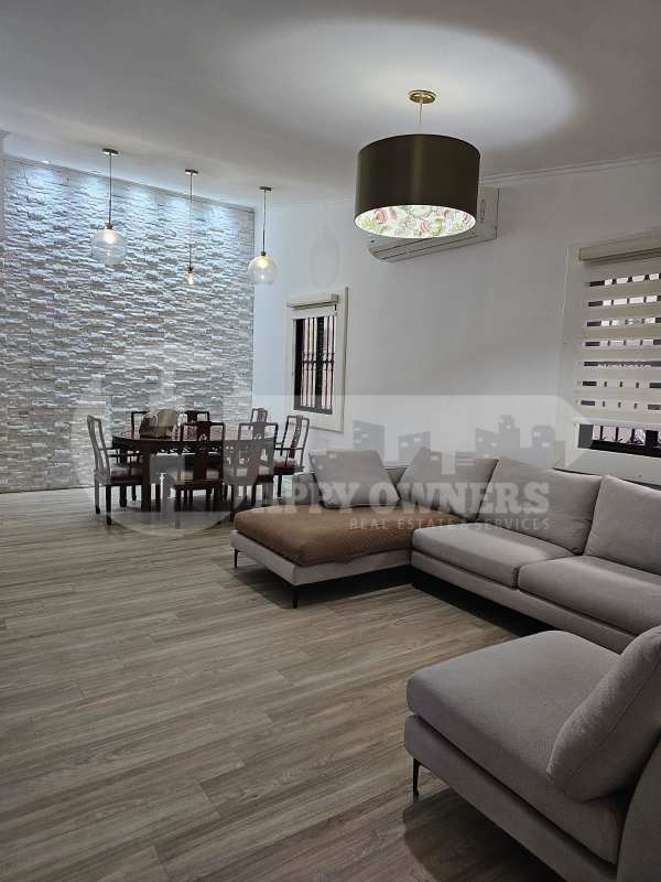 Open concept living and dining with textured wall, pendant lights, and AC rental Panama City