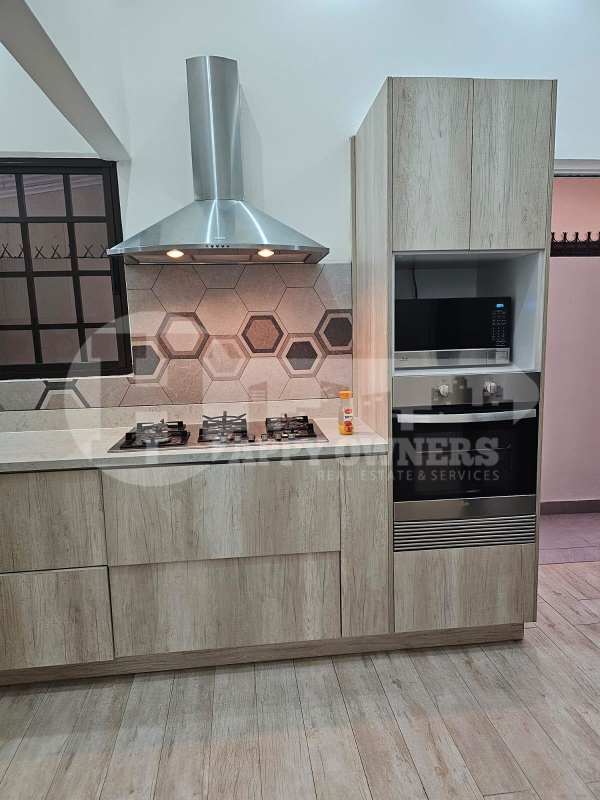 Remodeled kitchen with wood cabinets, hexagon backsplash, oven, gas cooktop in Panama rental home