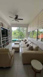Bright living room with AC, ceiling fan and large windows at Nueva Gorgona house for sale