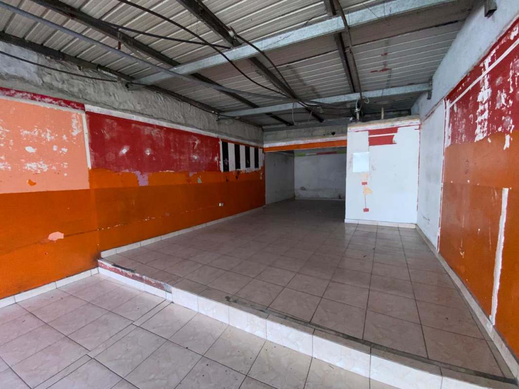 Vacant commercial interior with tiled floors raised area exposed ceiling beams in Pedregal Panama