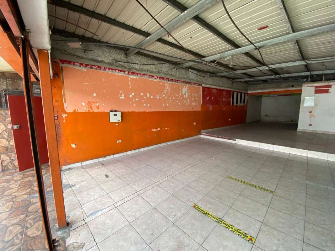 Commercial retail space with tile floor, elevated platform area, peeling paint Pedregal Panama