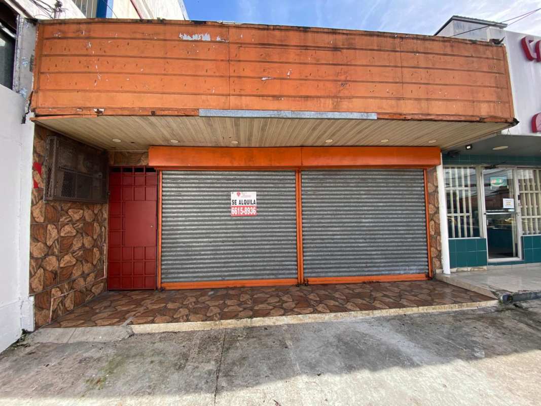 Storefront closed with double rolling metal shutters and stone facade Pedregal Panama