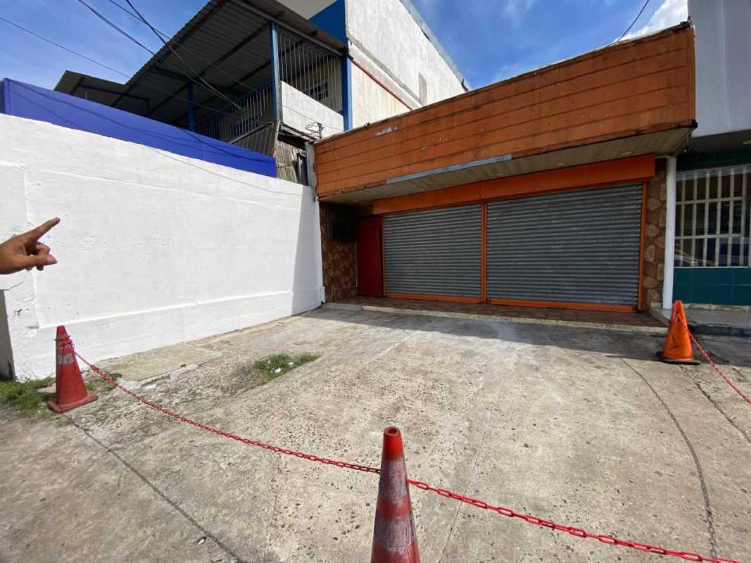 Large empty commercial interior with colorful peeling walls elevated stage Pedregal Panama