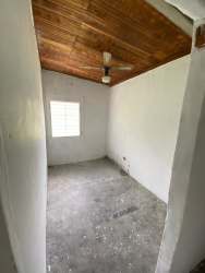 Enclosed sunroom with concrete floor and wooden ceiling overlooking yard Nueva Gorgona