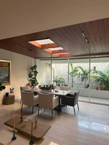 Living room with sectional sofa, wood flooring, large window in urban house San Francisco Panama