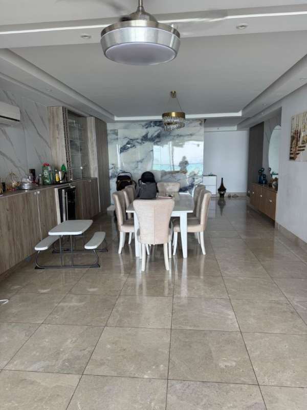 Spacious dining room with marble floor, accent wall, modern chandelier PH Costanera Panama City
