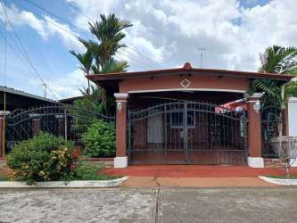 Living room with orange accent wall, ceramic tile floors and window in Villas del Campo La Chorrera Panama