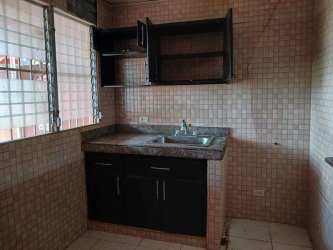 Compact kitchen space with cabinets, granite countertop, and tiled backsplash in Villas del Campo La Chorrera Panama