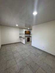 Bright open plan kitchen and living room with tile flooring in Penonomé apartment for rent