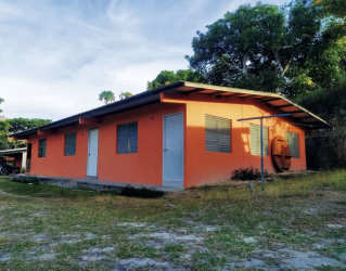 Low-rise triplex building with orange walls and yard Penonomé apartment for rent