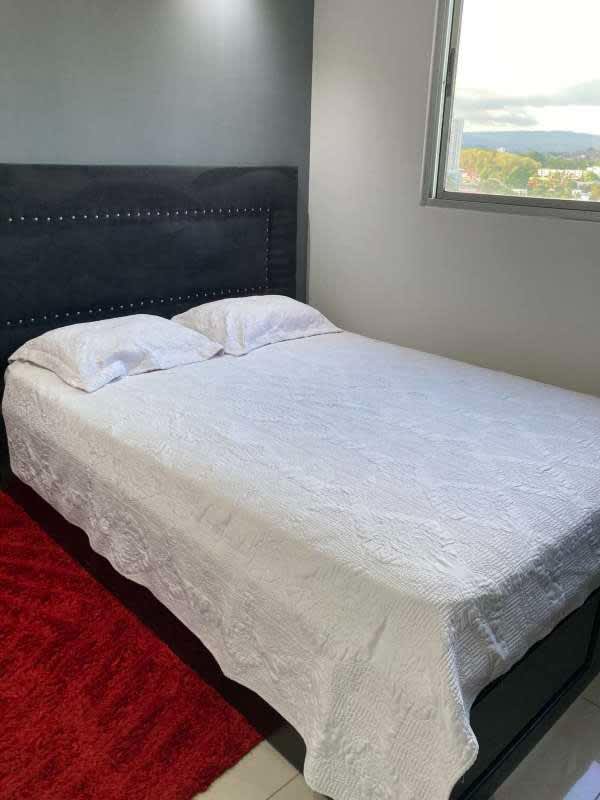 Modern bedroom with accent wall, tile floor and large window at PH Centennial Panama