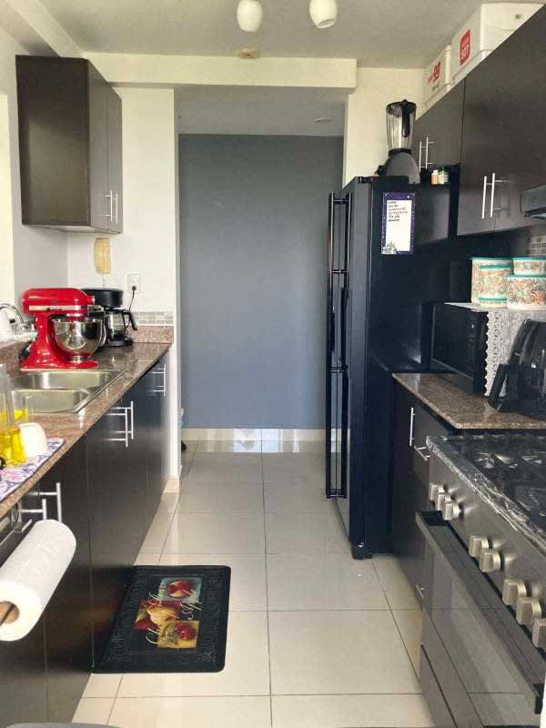 Modern galley kitchen with granite counters, gas stove and cabinets PH Centennial Panama