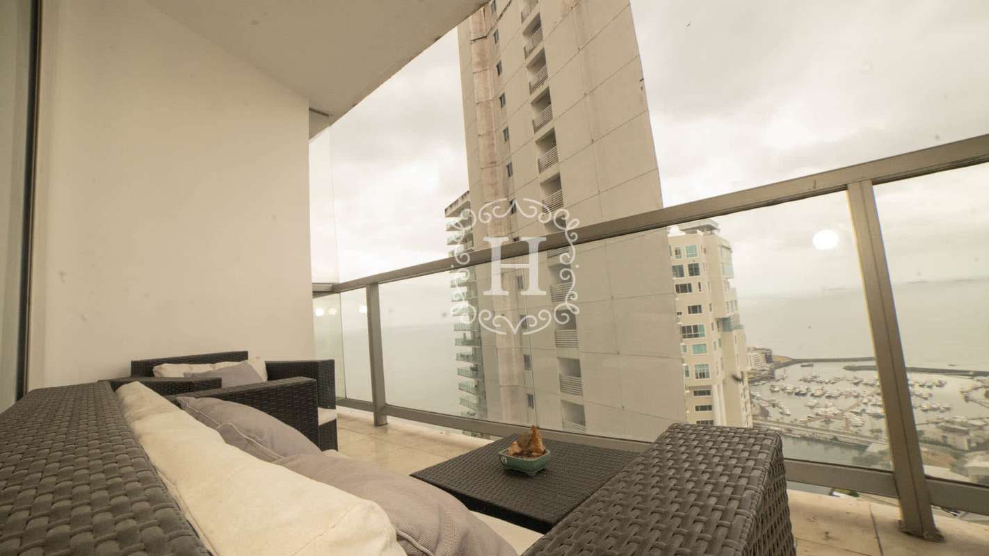 Spacious open-concept kitchen and living room with floor-to-ceiling windows overlooking ocean and Panama skyline at The Ocean Club