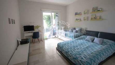 Modern minimalist bedroom with balcony access, garden view and natural light at Puntarena Beach Club Panama