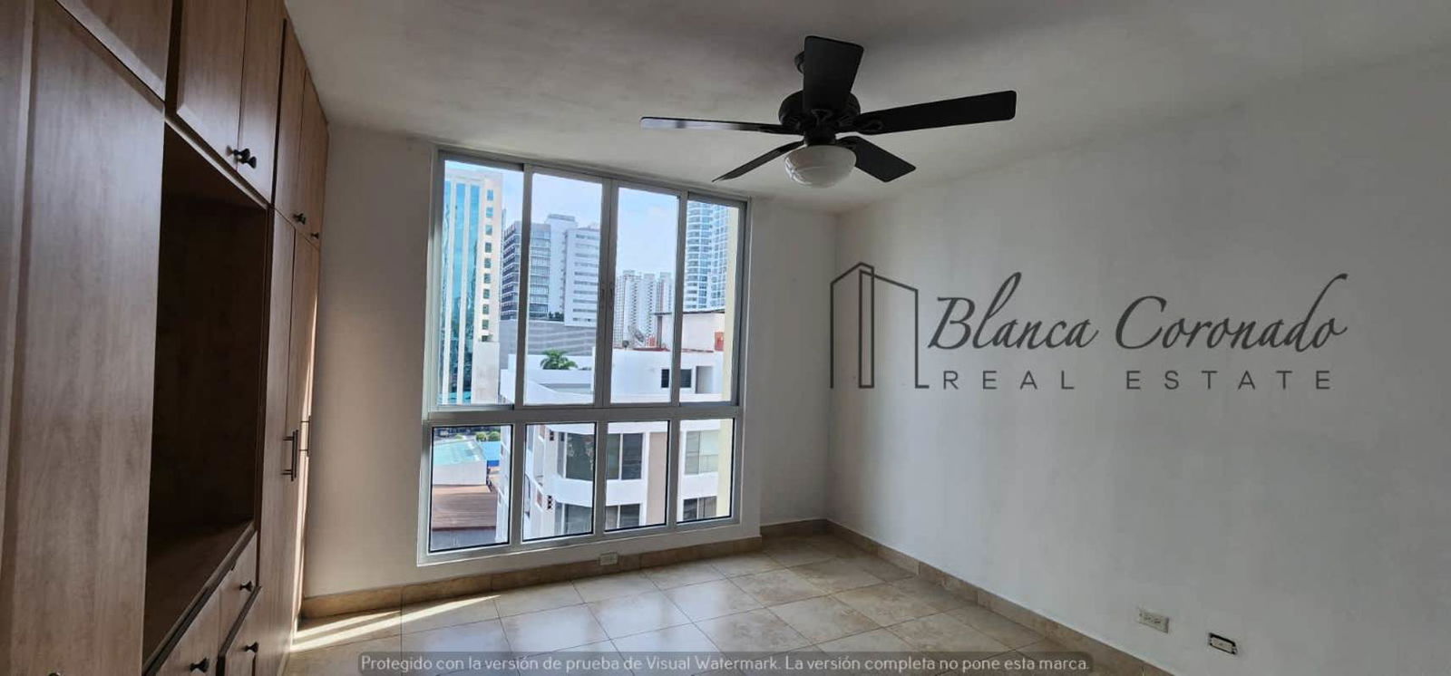 Dining space with large glass doors leading to balcony city skyline view PH Portofino Panama City