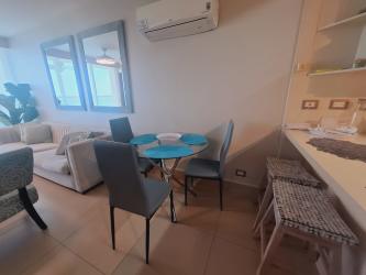 Fully equipped kitchen with white cabinets, breakfast bar, appliances at PH Bahia Resort Playa Gorgona Panama