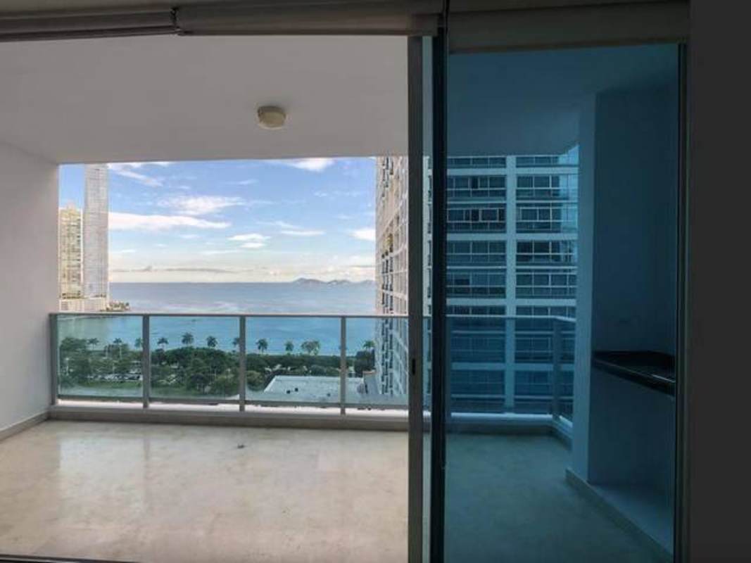 Modern living room with balcony overlooking ocean and city skyline in PH Mar Abierto Panama City