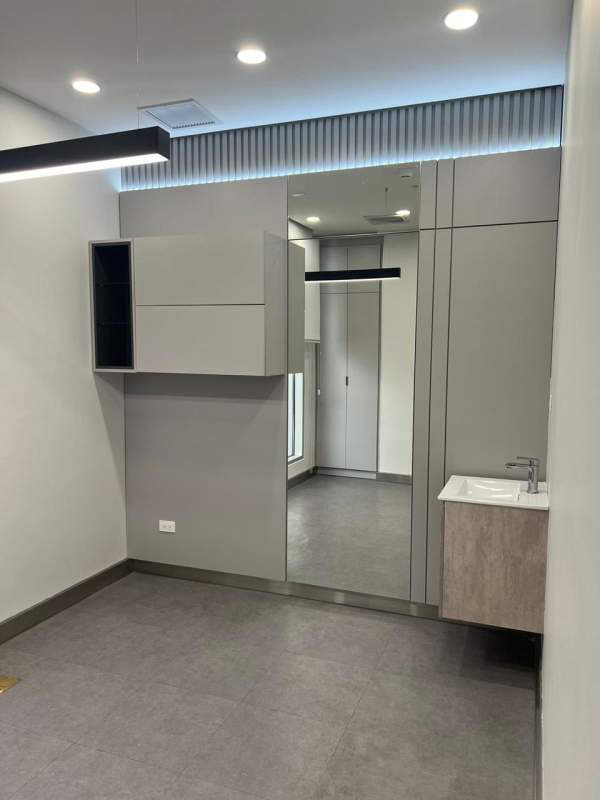 Modern commercial office bathroom with floating sink and large mirror Town Center Costa del Este