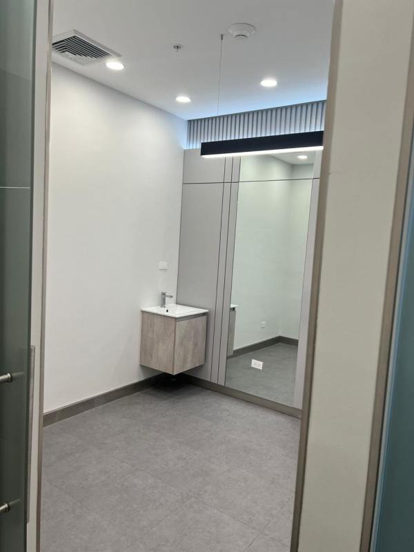 Minimalist modern bathroom with floating wood vanity, large mirror in Town Center Costa del Este Panama City