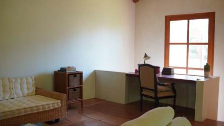 Open living room with large glass doors, wood ceiling beams and garden views at Los Destiladeros Pedasí