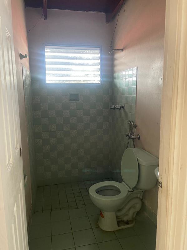 Basic bathroom with tiled walls and toilet inside commercial unit PH Altos del Chase El Dorado Panama
