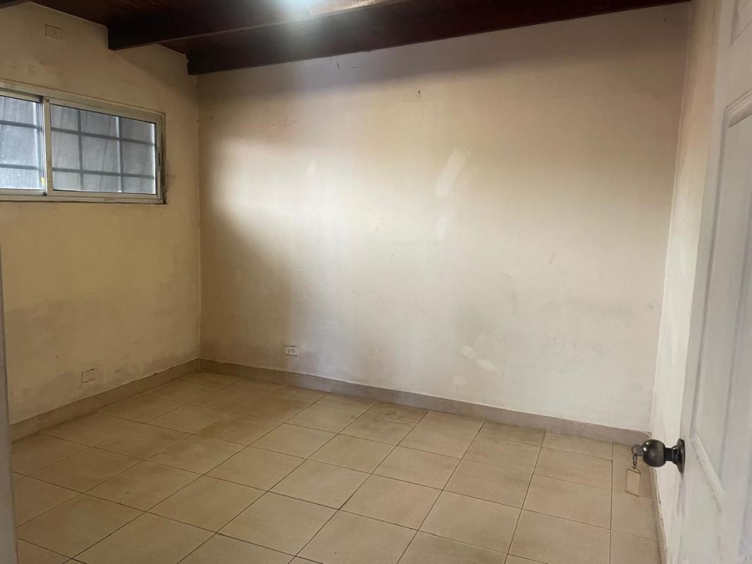 Interior empty room with windows, tiled floor and ceiling beams in PH Altos del Chase El Dorado Panama