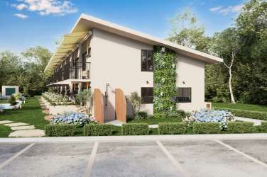 Modern beach condo complex exterior with balconies, large windows and garden landscaping at Playa Venao
