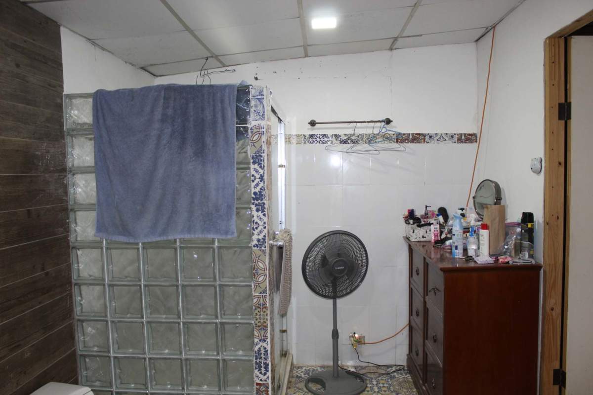 Bathroom with decorative mirror, wood cabinetry, ceramic tile floor in Cerro Azul property