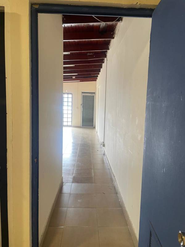 Interior corridor with tiled floor, exposed beams and security door in Altos del Chase