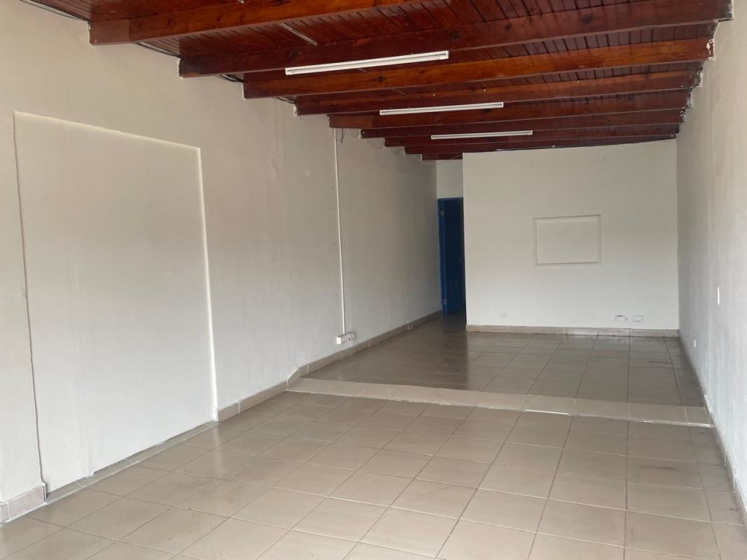 Empty two-level commercial interior with tiled flooring and exposed beams in Panama City