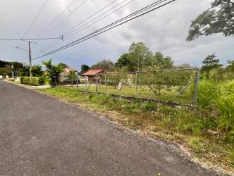 Street entrance view fenced vacant buildable lot in Golf & Beach Resort Coronado Panama