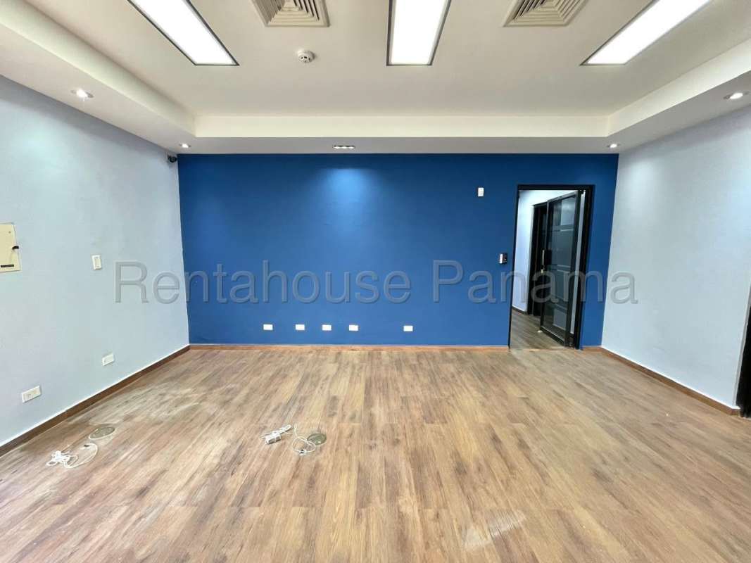 Large open office space with wood flooring, blue accent walls, glass partitions for rent in Costa del Este Panama