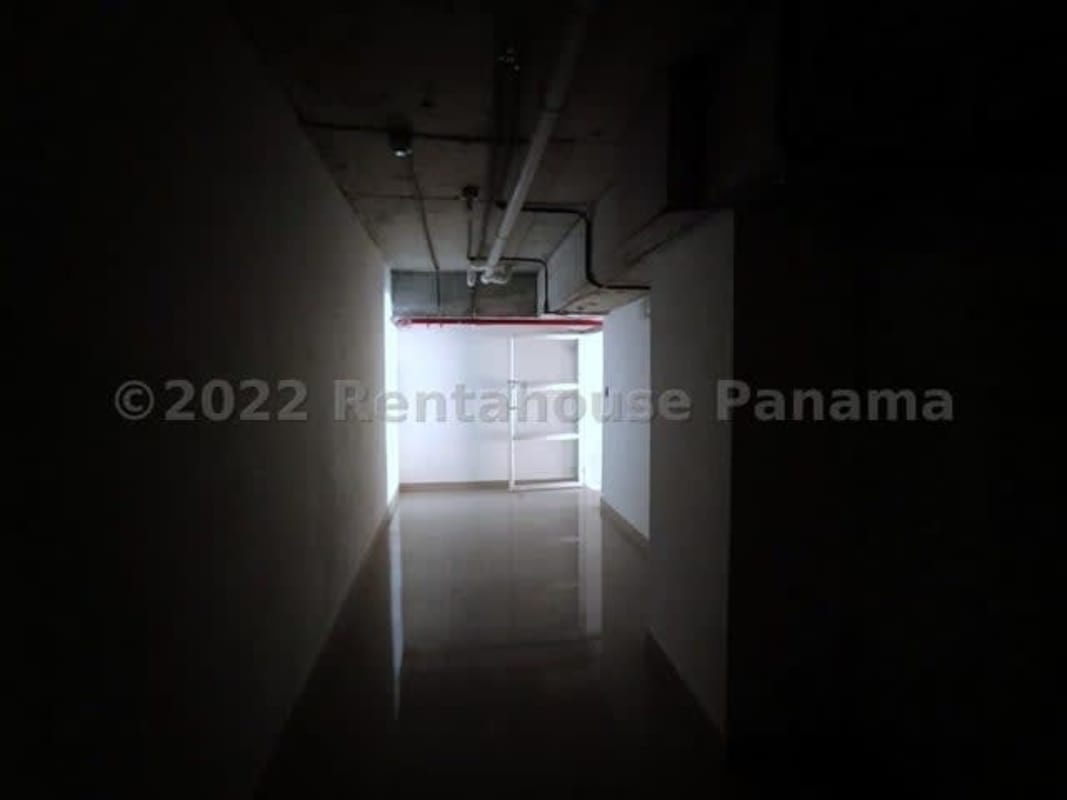 Industrial style hallway with visible pipes and polished concrete floor in retail property Panama