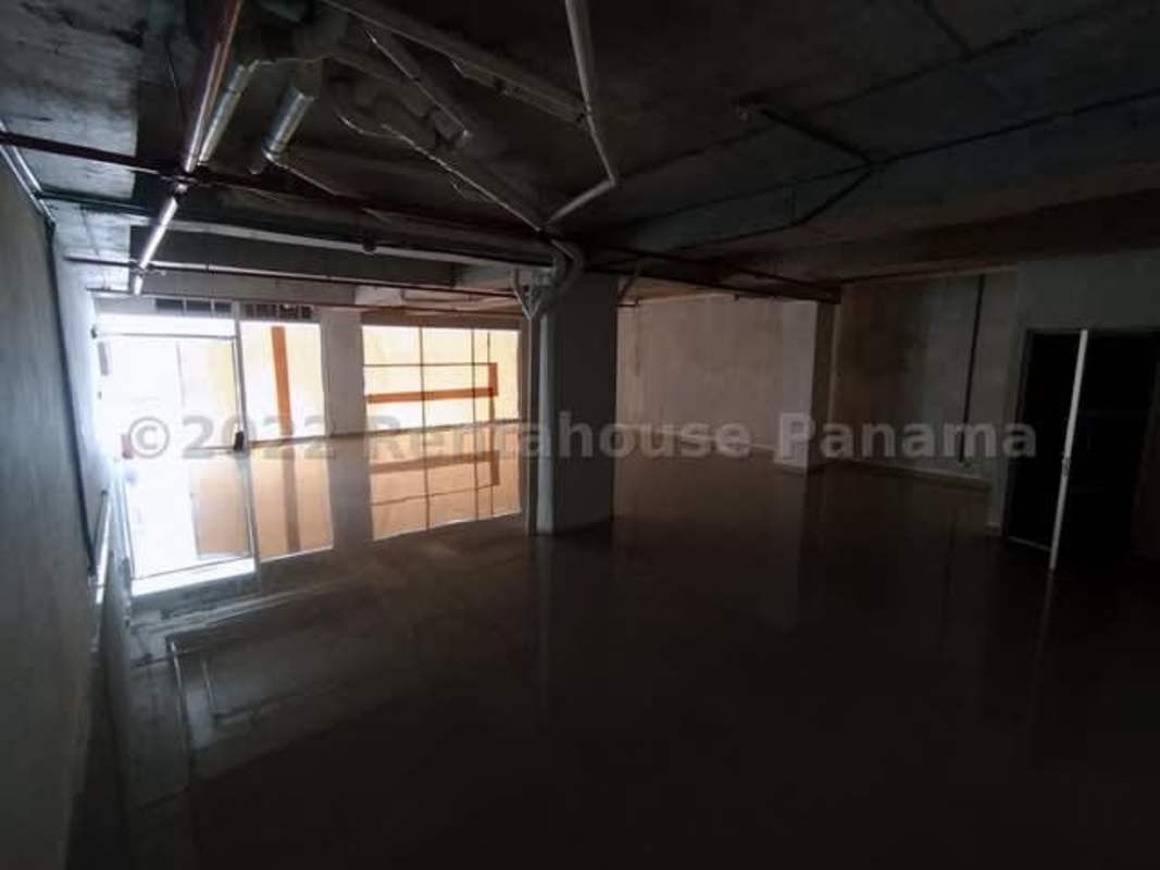Large open raw commercial interior with concrete walls and reflective floor in Pueblo Nuevo