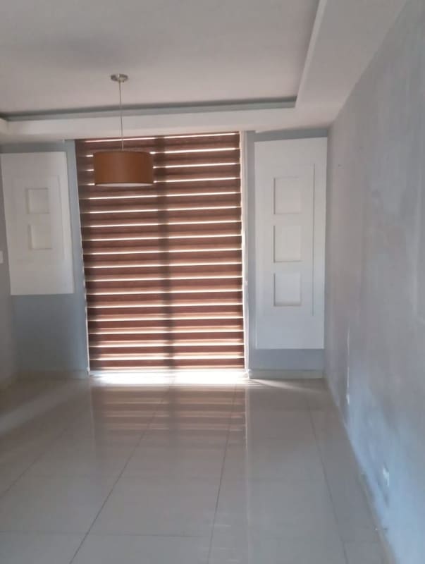 Modern empty living room with tiled flooring and pendant light in PH Azahares Pedregal Panama City